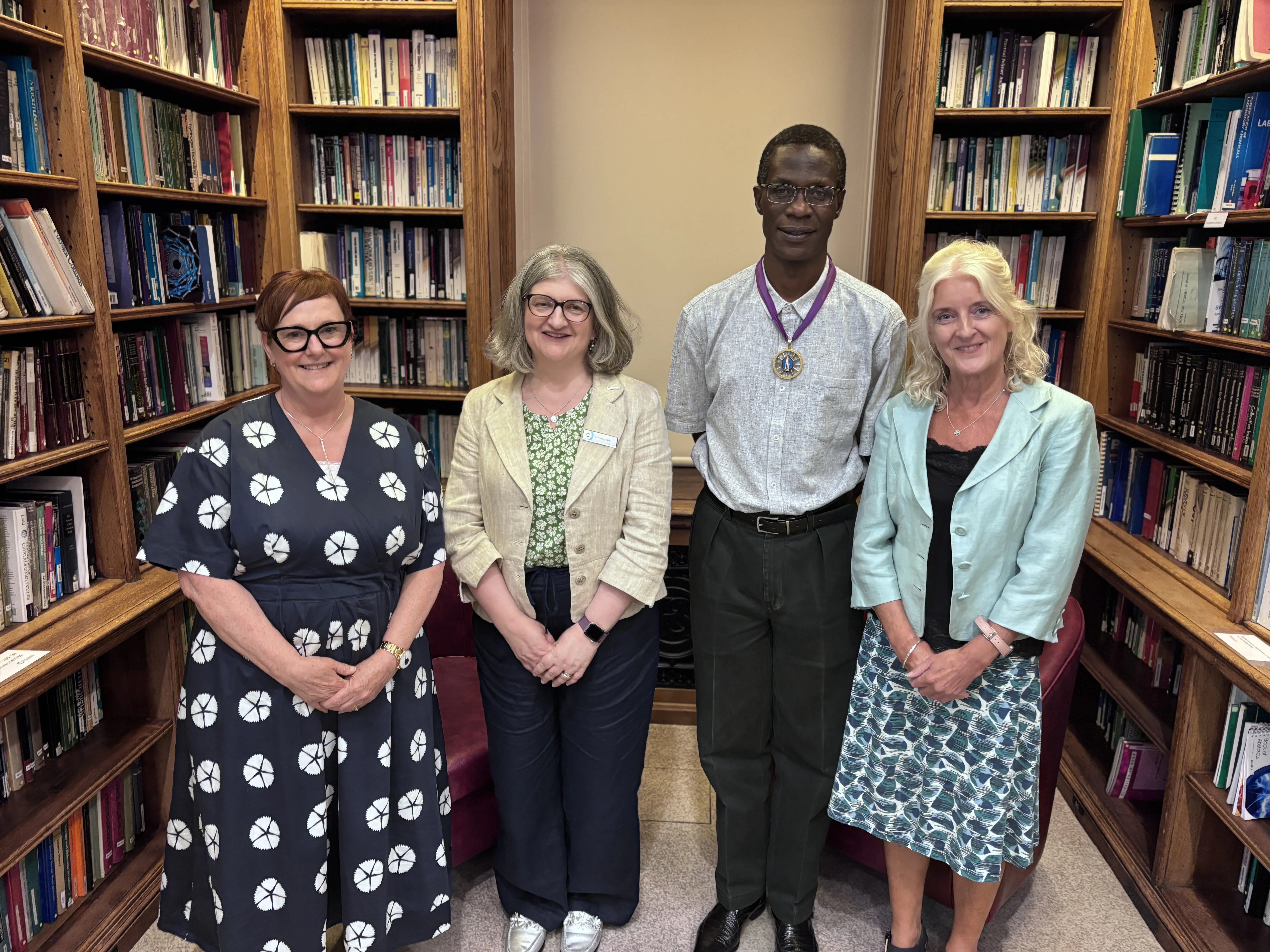2026 AGM - Mandy Cooke, Helen Pain, Robert Mokaya and Annette Doherty Honorary Treasurer Dr Mandy Cooke, CEO Dr Helen Pain, President Professor Robert Mokaya and Past President Dr Annette Doherty stand in front of shelves of old books in the Library Room