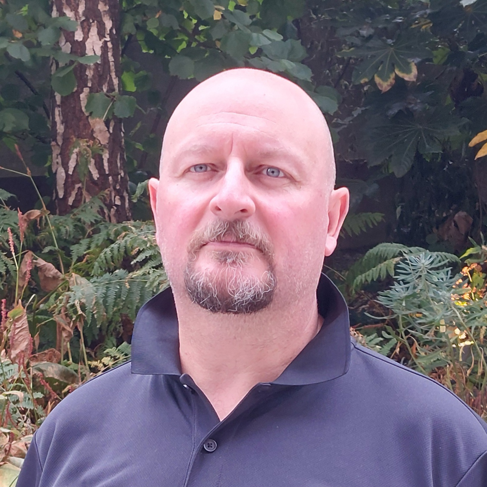 a man standing outside in front of trees