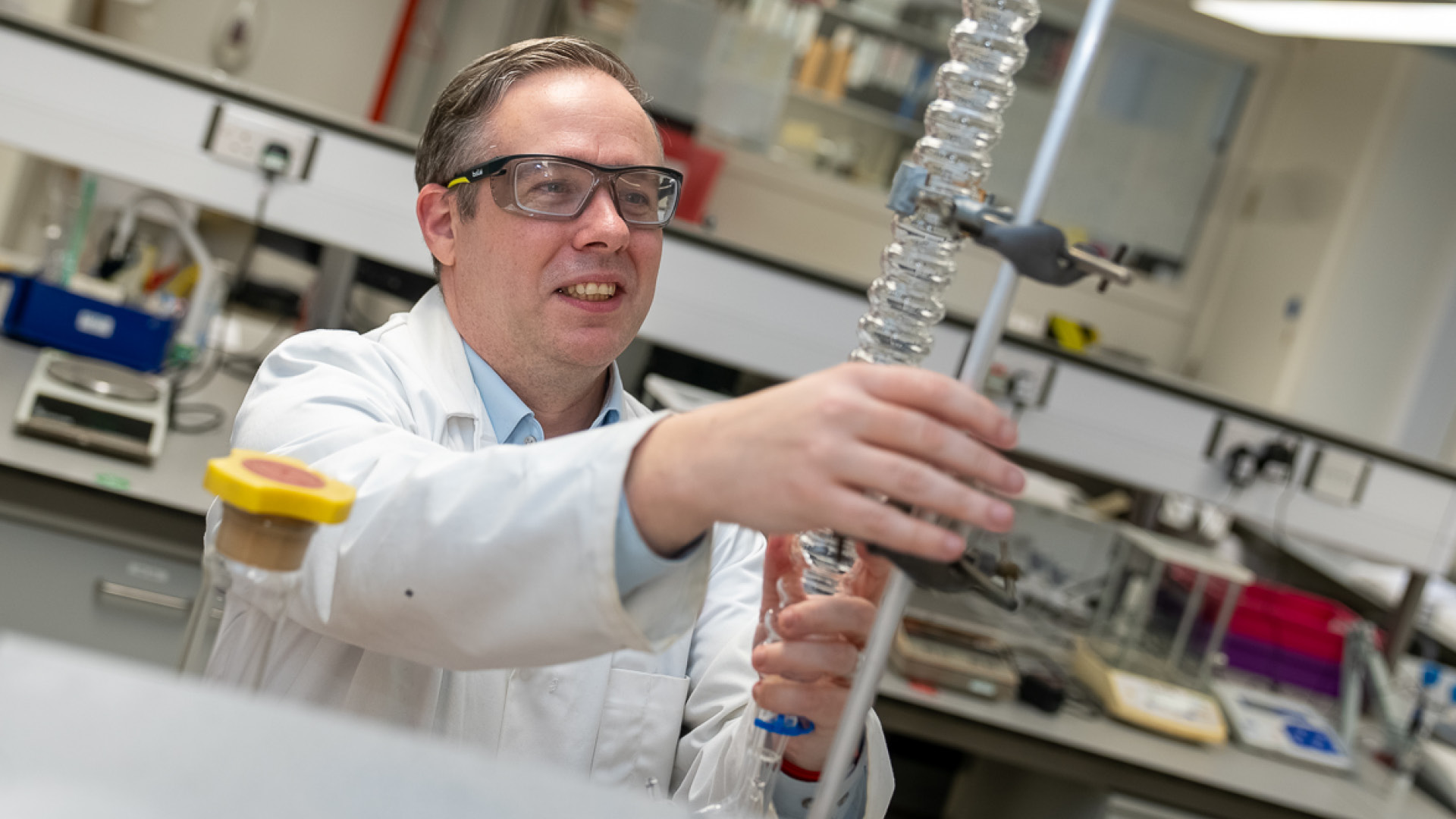 Kevin Morgan carrying out lab work in safety glasses and lab coat
