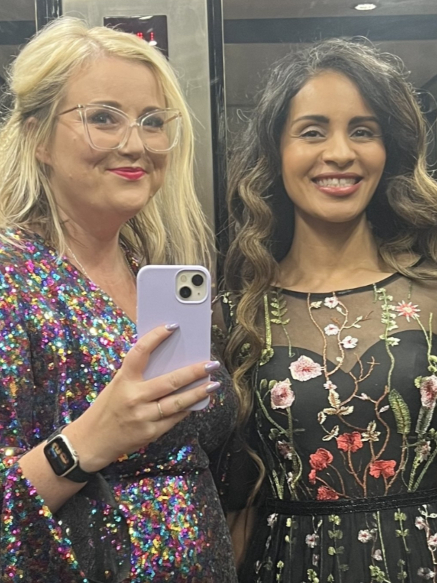 Jorden and Laura smiling to camera in cocktail dresses