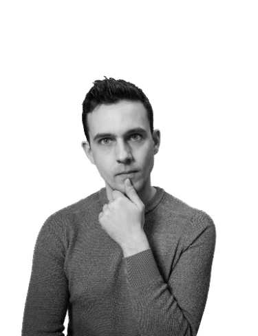 A black and white portrait of Jan Gerit Brandenburg, resting his chin on his hand against a white background.
