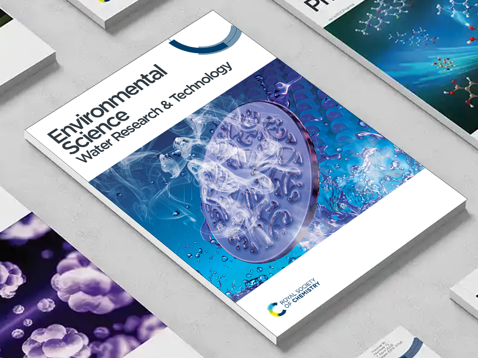 the Environmental Science Water Research & Technologies journal among a group of other journals on a desk