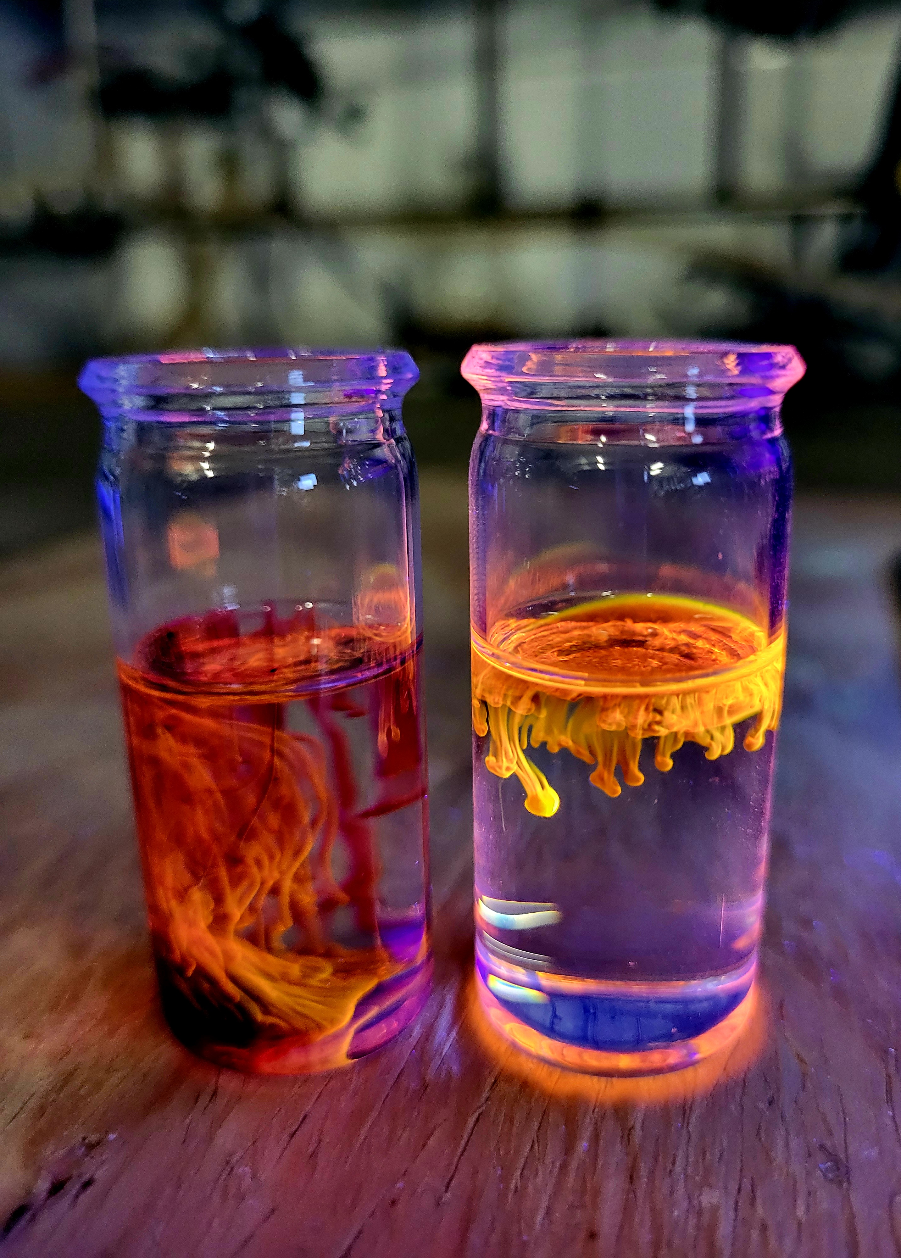 Maciek Majdecki's 'Fall Chemistry Trapped in a Vial' shows a couple of small jars filled with liquid on a wooden counter top