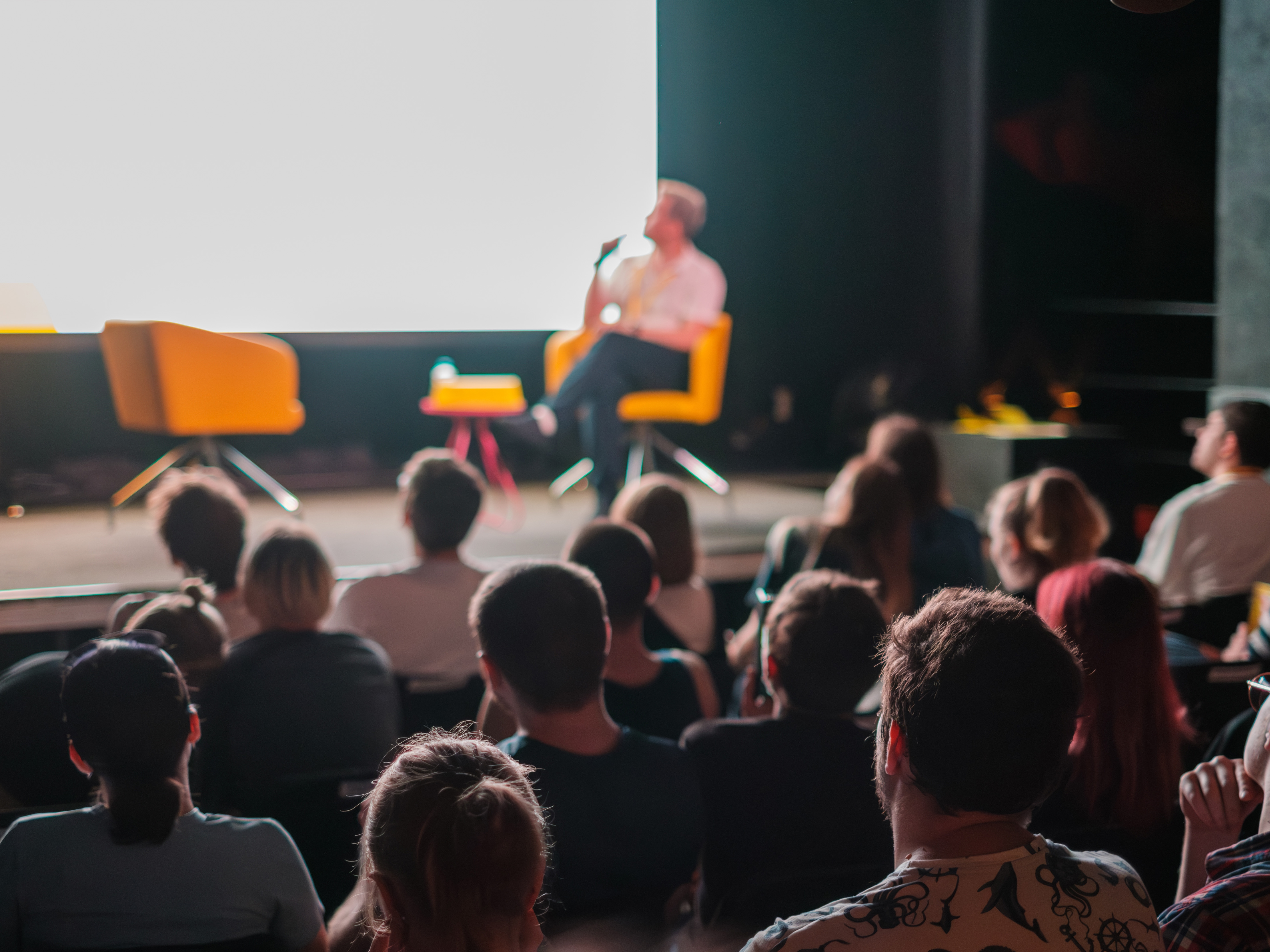 people sitting in a conference room listening to a speaker