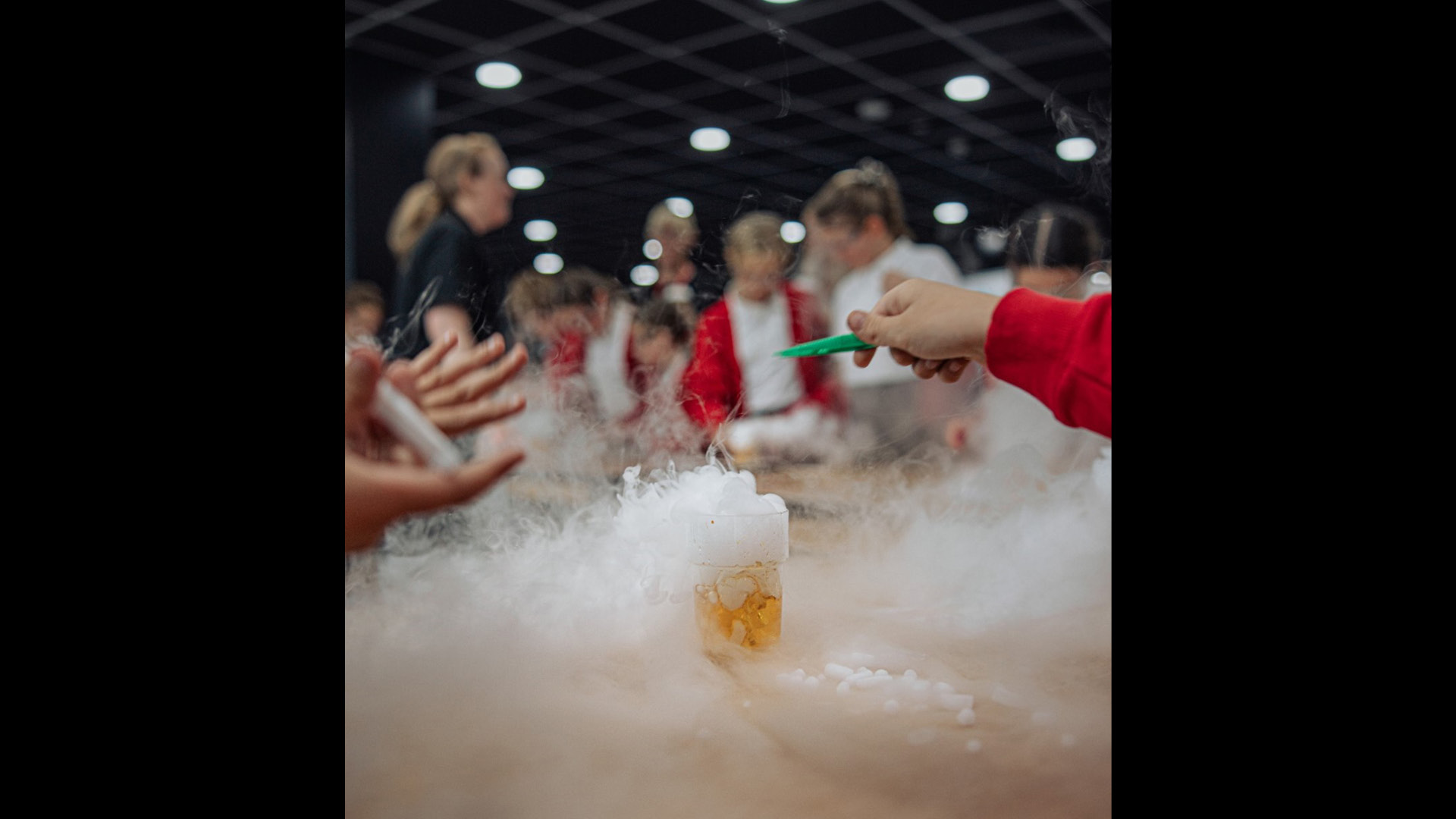 Out of focus - children in school uniform doing an experiment that creates foam