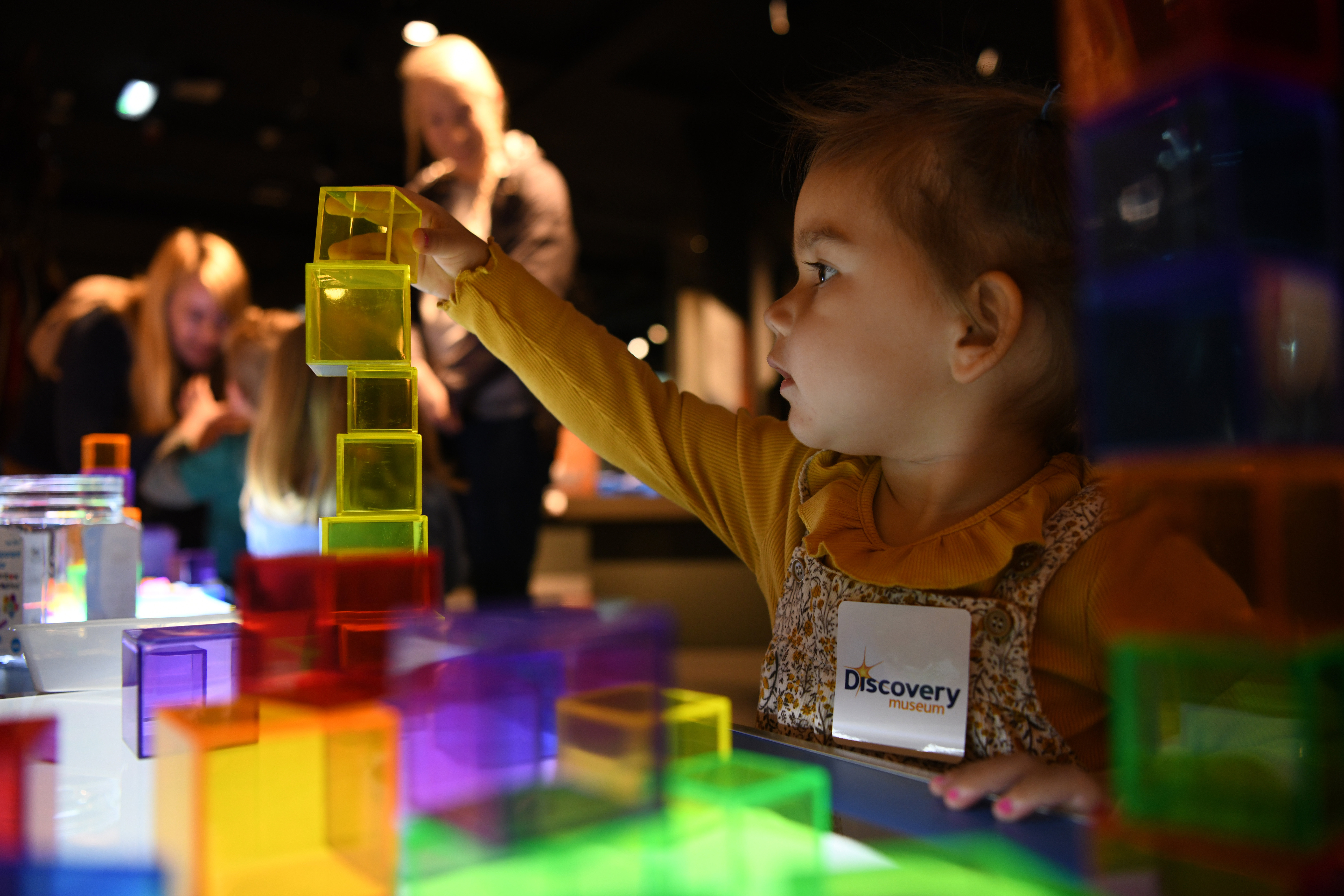 A young child plays with multi-coloured blocks in the museum.