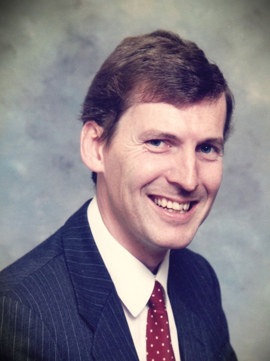 The late Ian Jeffrey Hotchkiss smiling to camera wearing blue pin stripe suit and white shirt