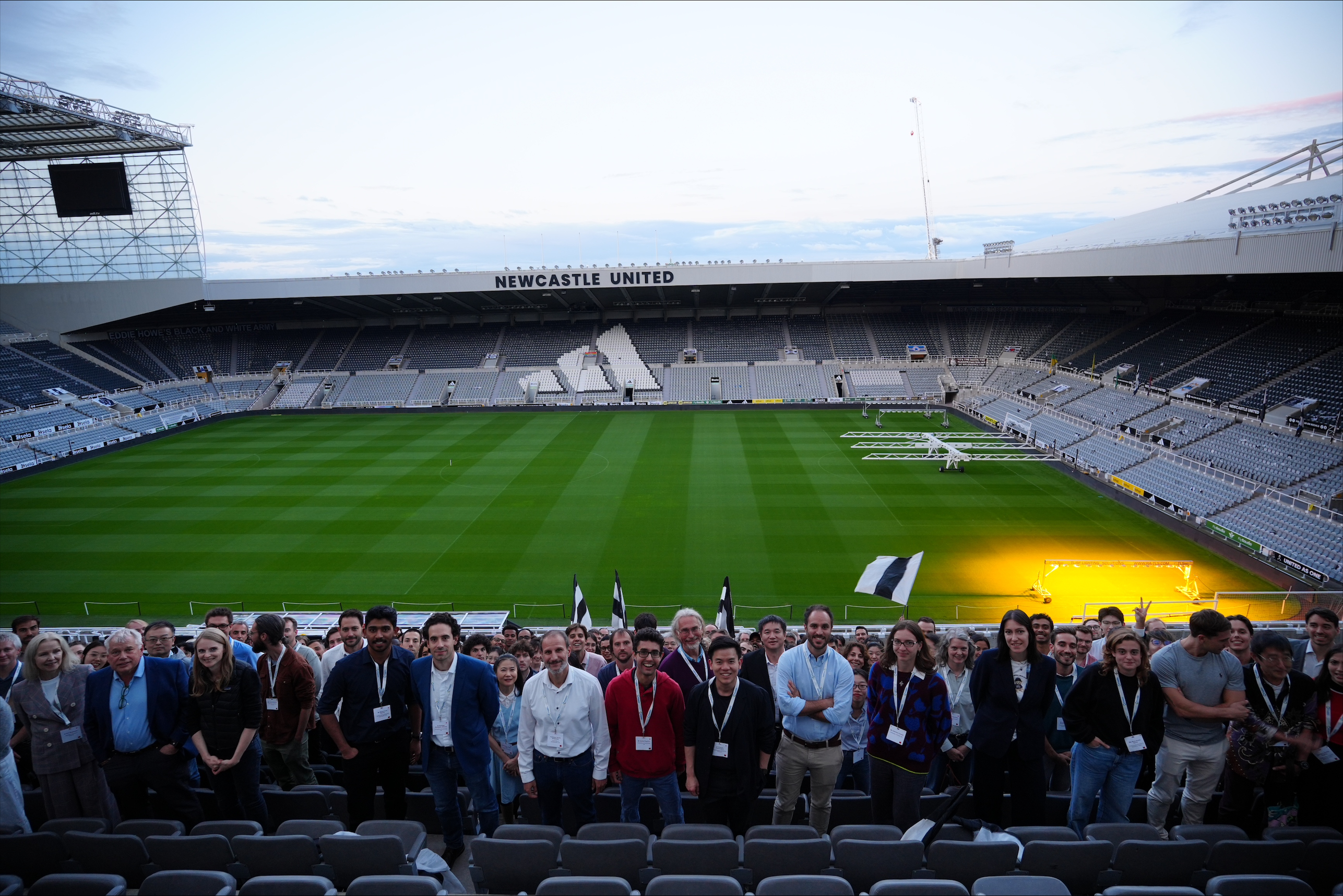 International Solar Fuels Conference delegates pose and hold flags at Newcastle United's St James' Park after a group meal