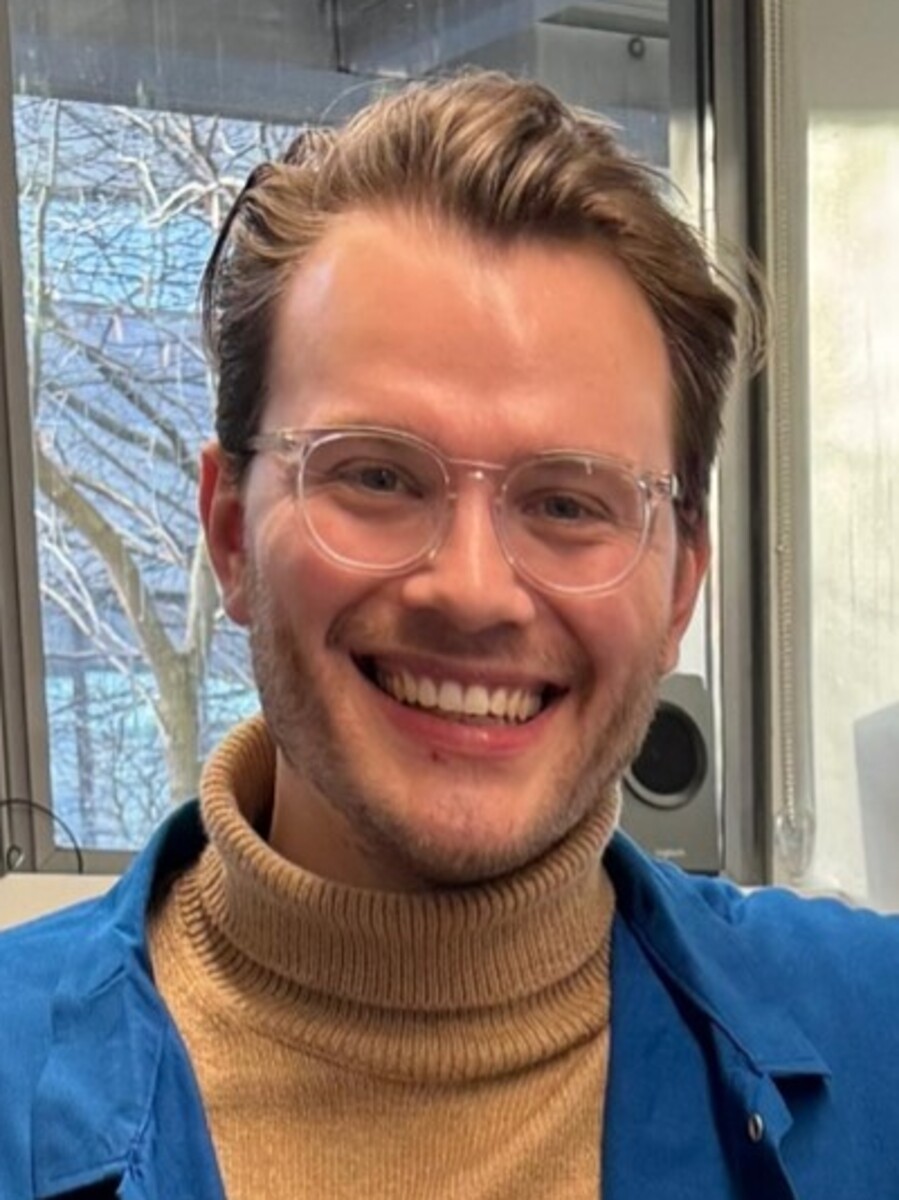 Christian Reece smiling to camera wearing glasses