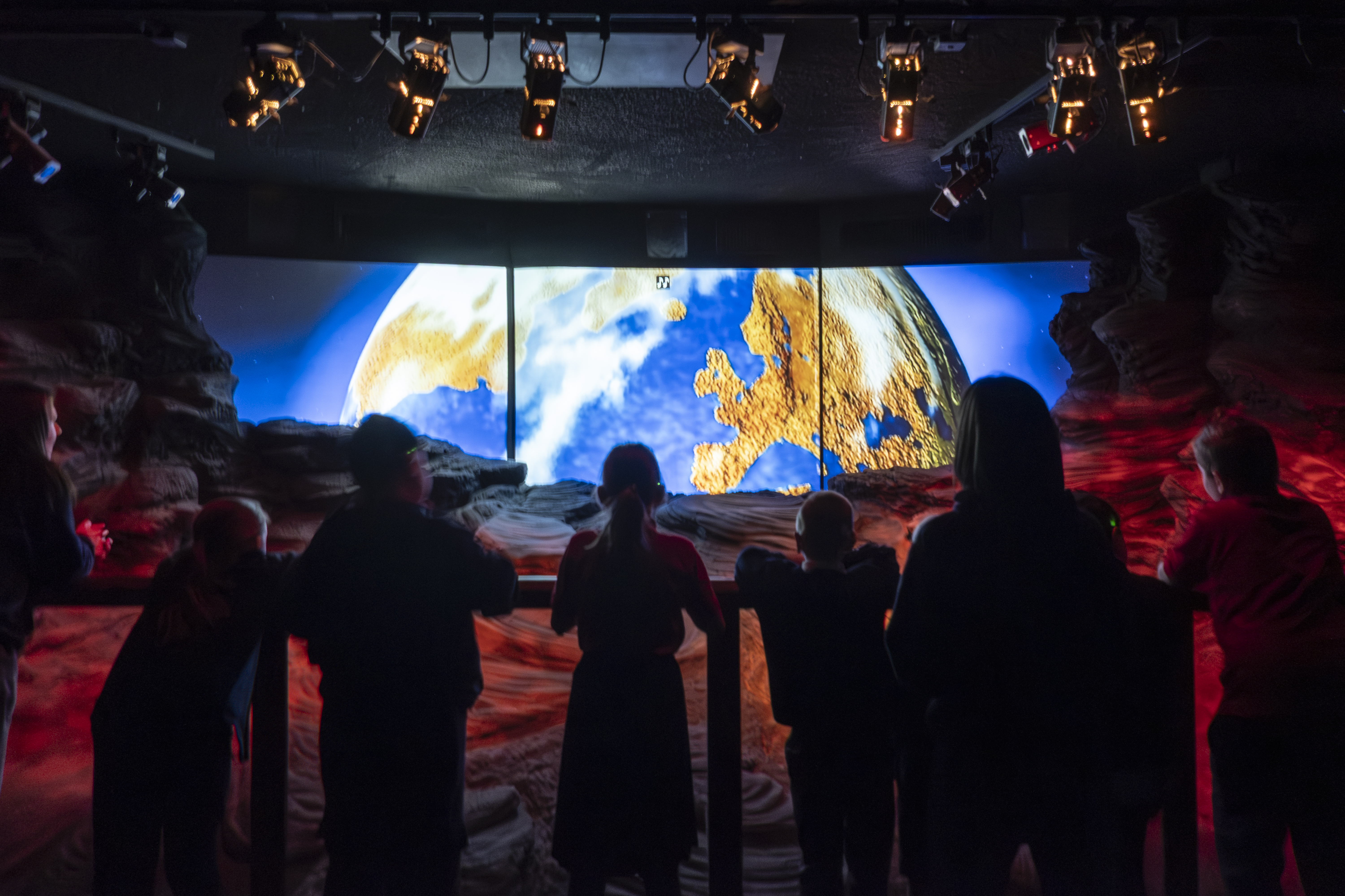 a group of people looking at a large screen