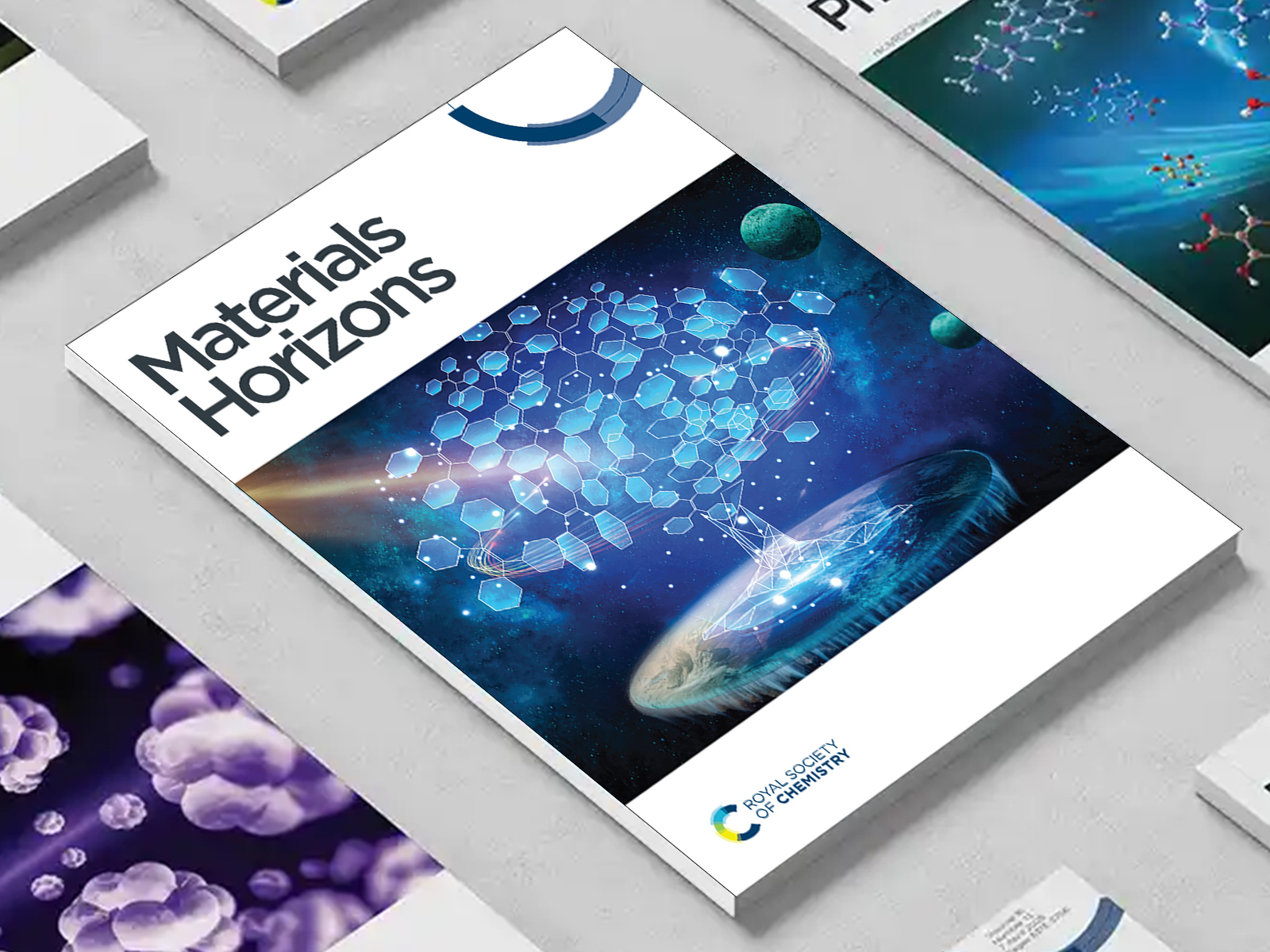 the Materials Horizons journal among a group of other journals on a desk