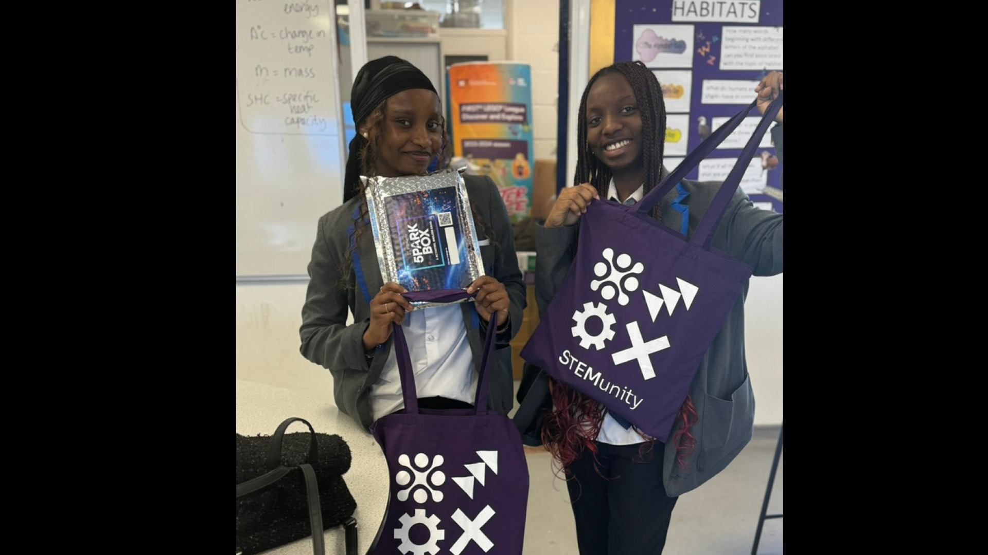 Two Black pupils showing their STEMUnity tote bags