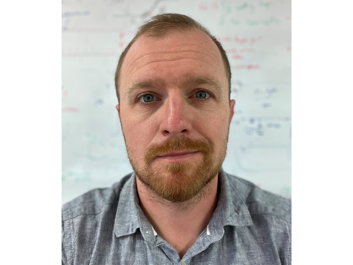 Dr Jon Major with a beard and mustache smiling for camera