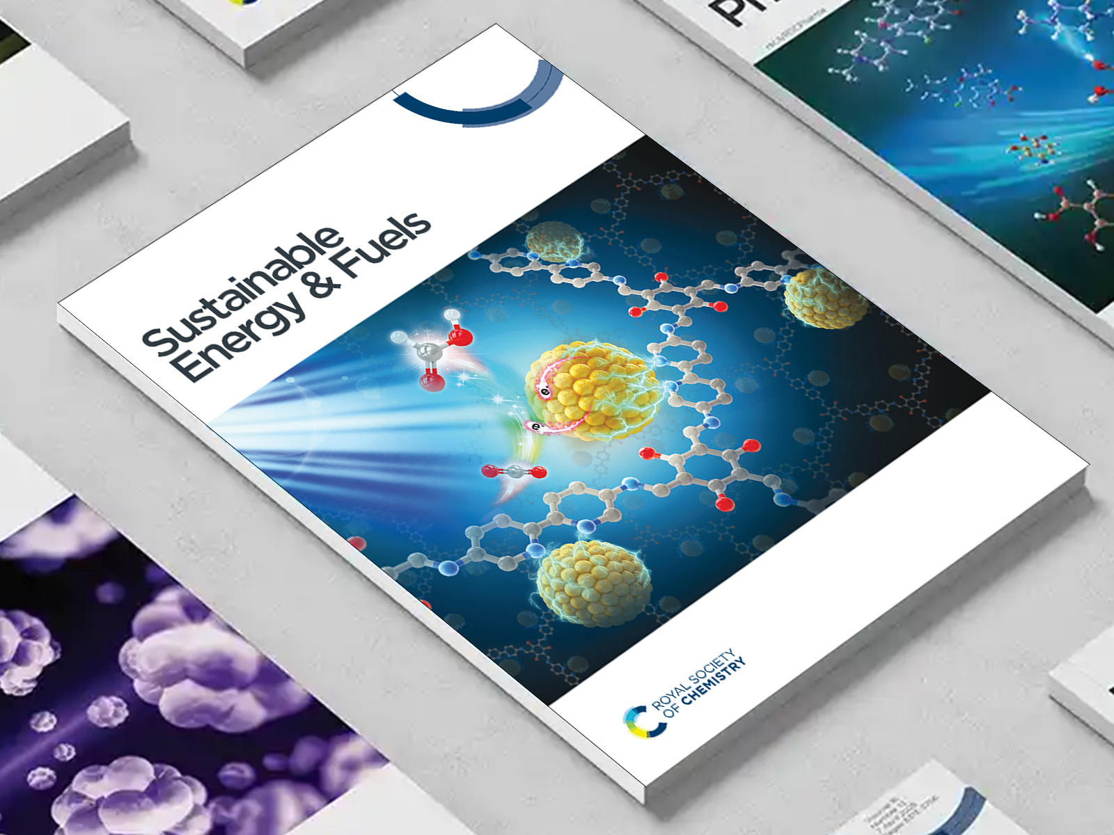 the Sustainable Energy & Fuels journal among a group of other journals on a desk
