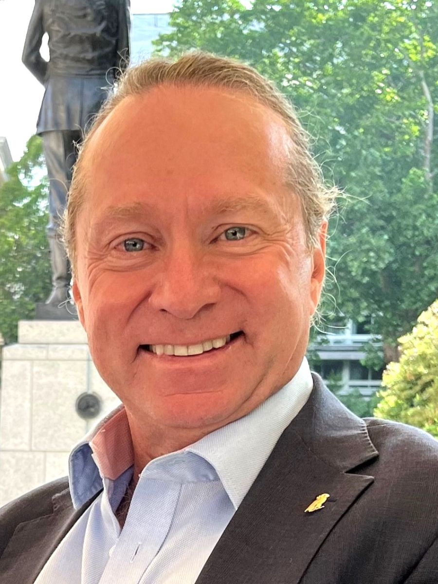 George Jackson smiling to camera in suit jacket and shirt