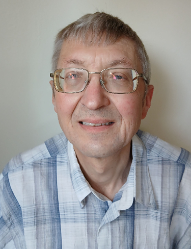 Headshot of Martin Fox smiling, wearing blue shirt with glasses