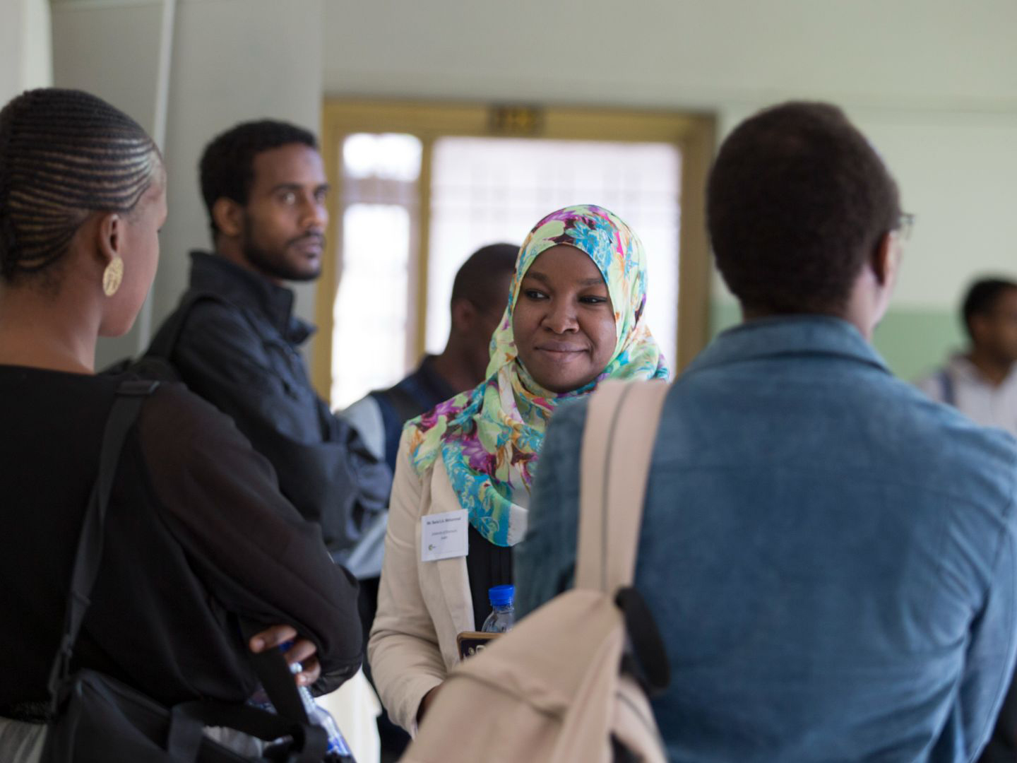 A Muslim woman standing with a group of people in an event