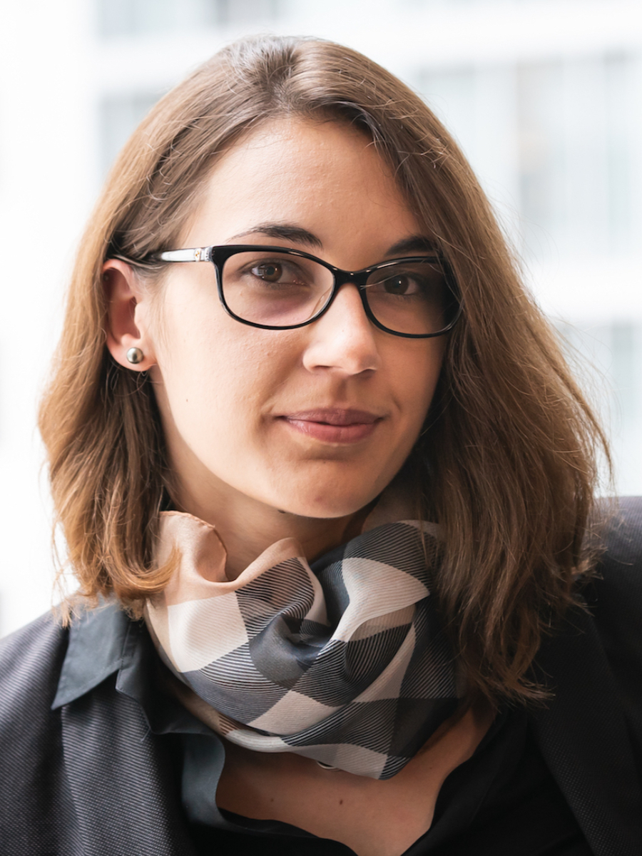 Jovana Milić headshot to camera, wearing glasses and patterned scarf