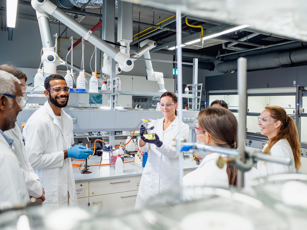 a group of people of different genders and races in lab coats in a lab
