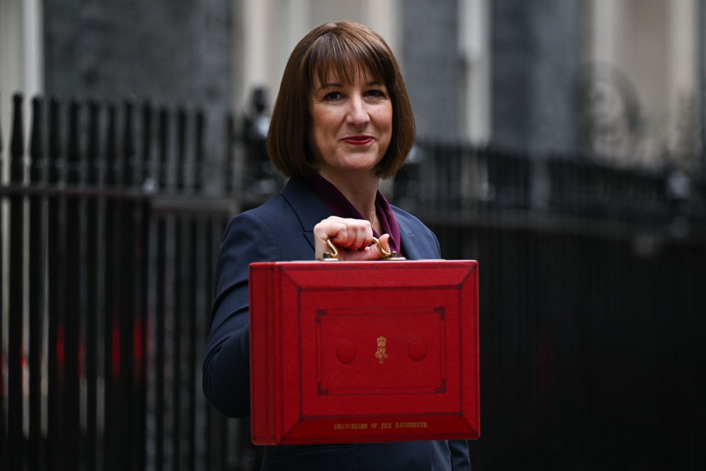 Chancellor of the Exchequer Rachel Reeves MP smiles and holds aloft a red dispatch box ahead of her Budget presentation to Parliament