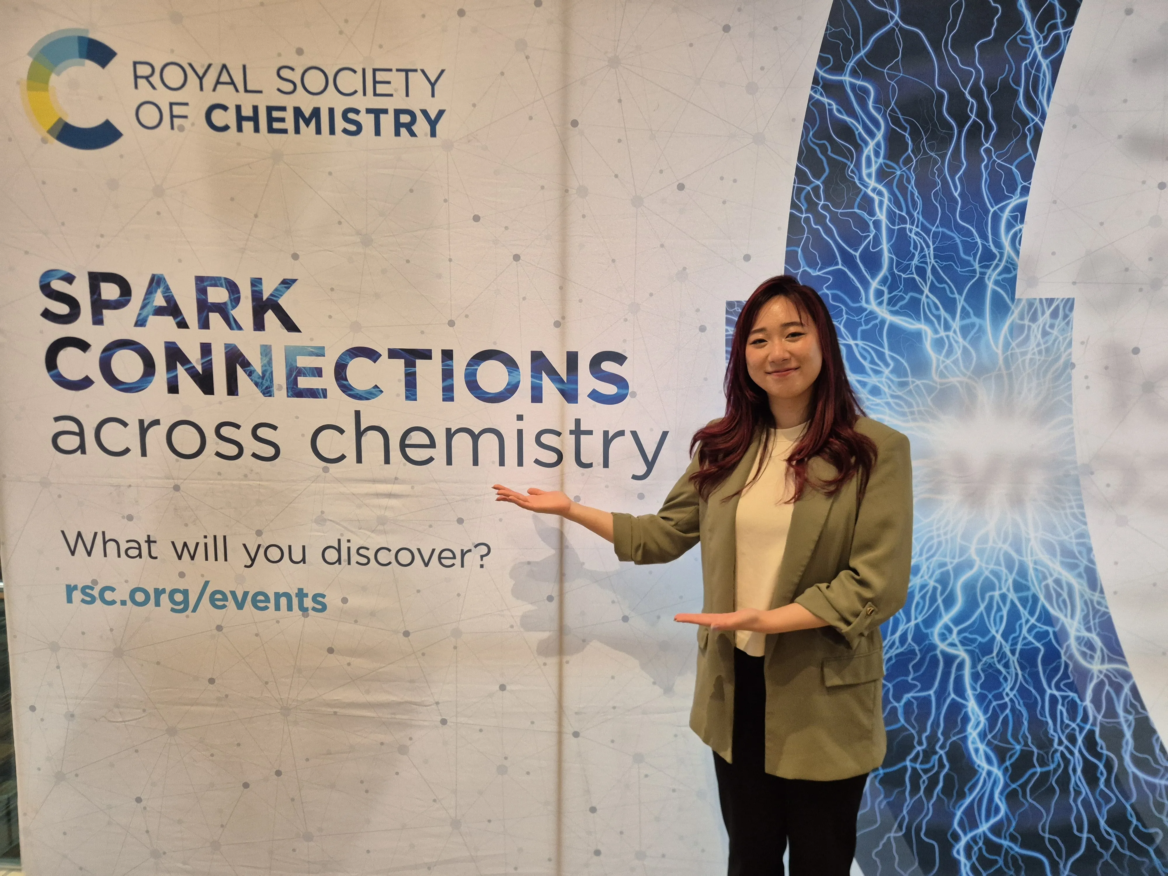 Broadening Horizons 5 - Ratu Sumampow Ratu Sumampow stands in front of a banner that reads Spark connections across chemistry with her hands underneath the text
