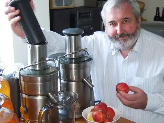 Nevin Stewart holds an apple before putting it through a Juice and Strain machine