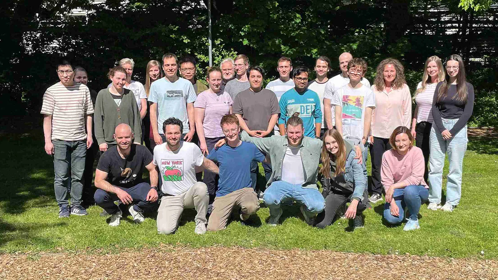 Professor Franziska Schoenebeck with a group of people posing for photo on grass outside