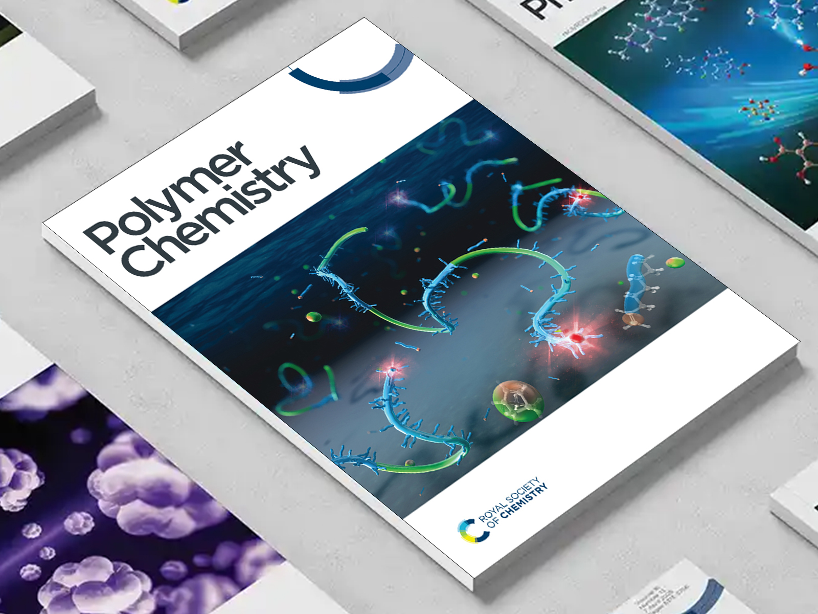the Polymer Chemistry journal among a group of other journals on a desk