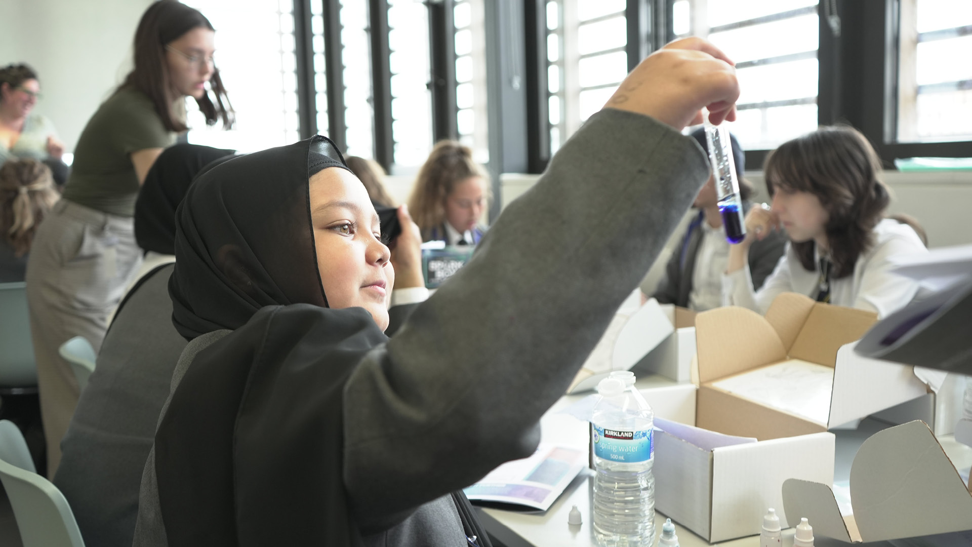 STEMunity students of different ethnicities holding up testubes