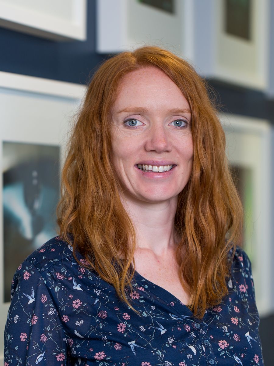 Laura Fisher smiling to camera wearing blue patterned blouse