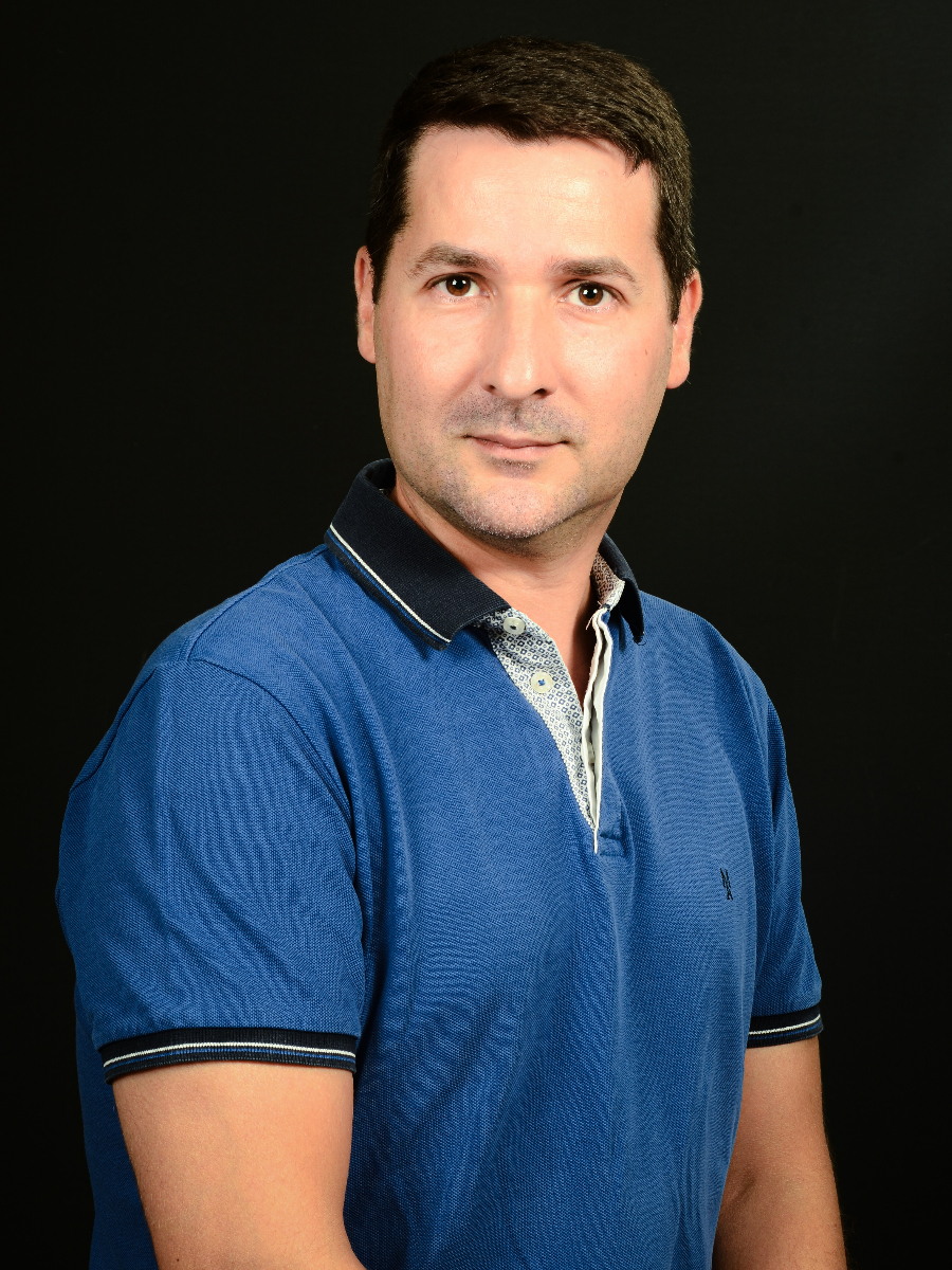 Eduardo Bolea-Fernández looking directly into the camera, wearing a blue polo shirt against black background.