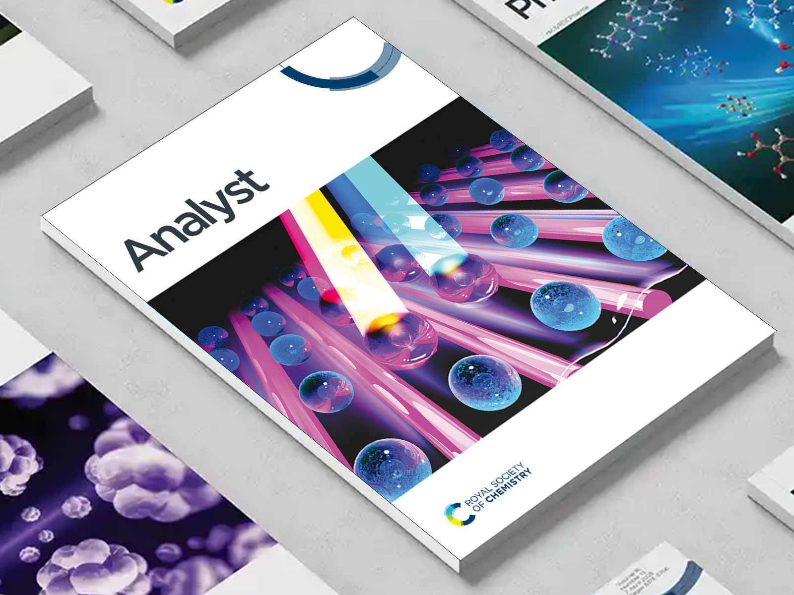 the Analyst journal among a group of other journals on a desk