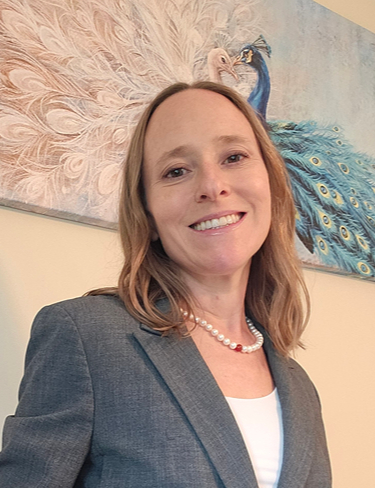 Christine Thomas, smiling in a grey blazer