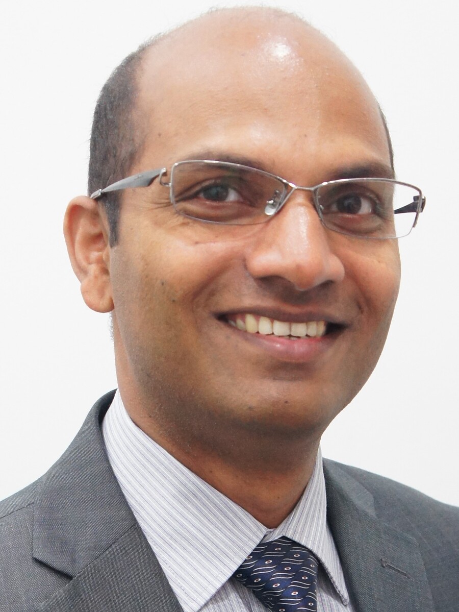 Ajayan Vinu smiling to camera wearing glasses, suit jacket and collared shirt