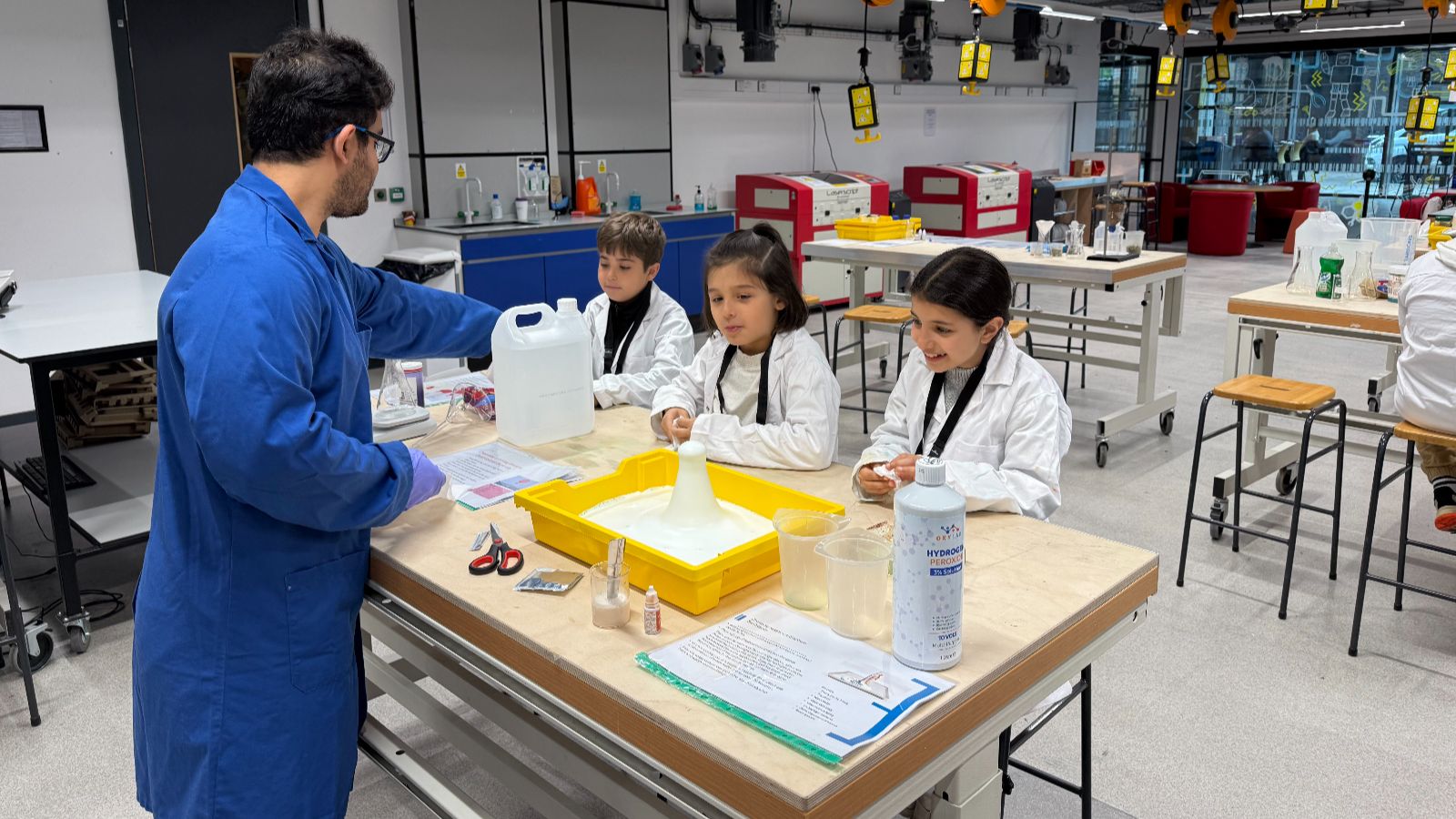 Syrian refugee school children at chemistry workshop with volunteer