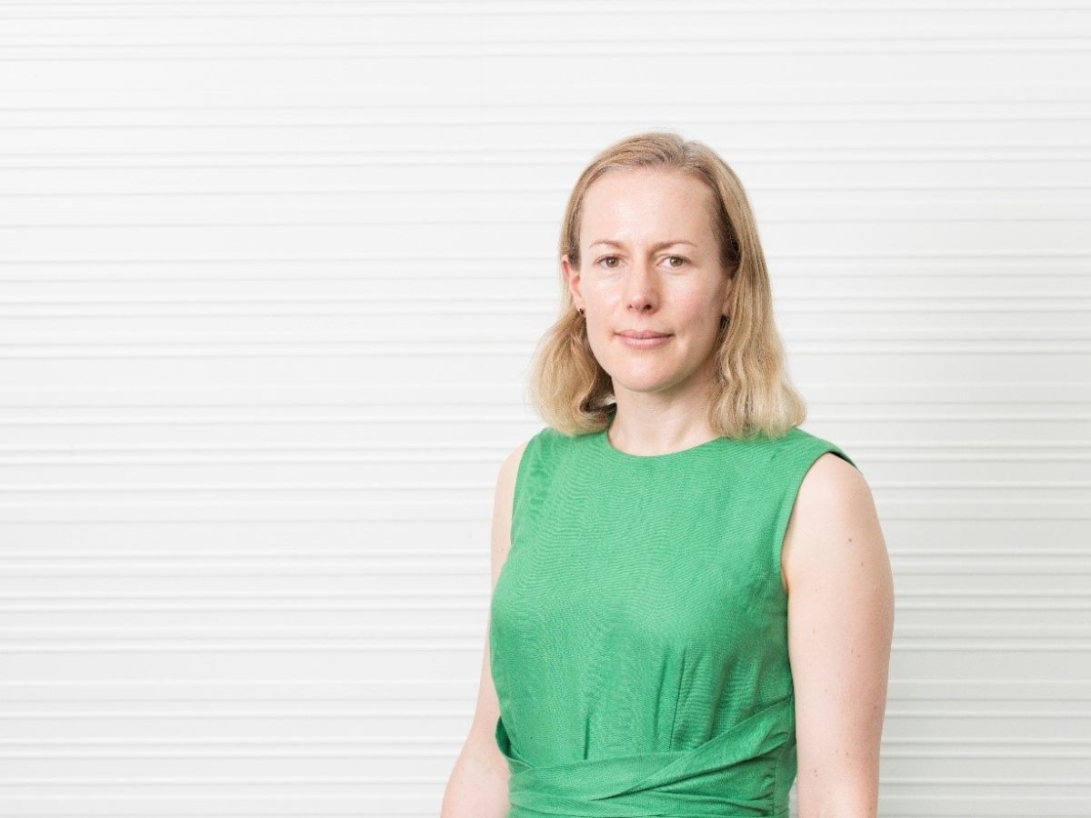 Tanya Sheridan against white wall in green dress