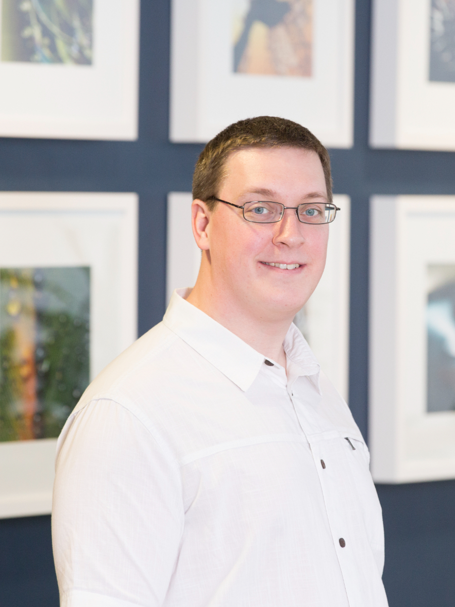 David Bishop smiling to camera in glasses and white shirt