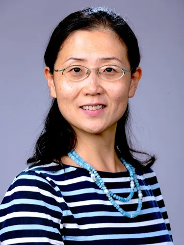 Yingmiao Liu Yingmiao Liu smiling wearing a black, blue and white striped top and glasses.