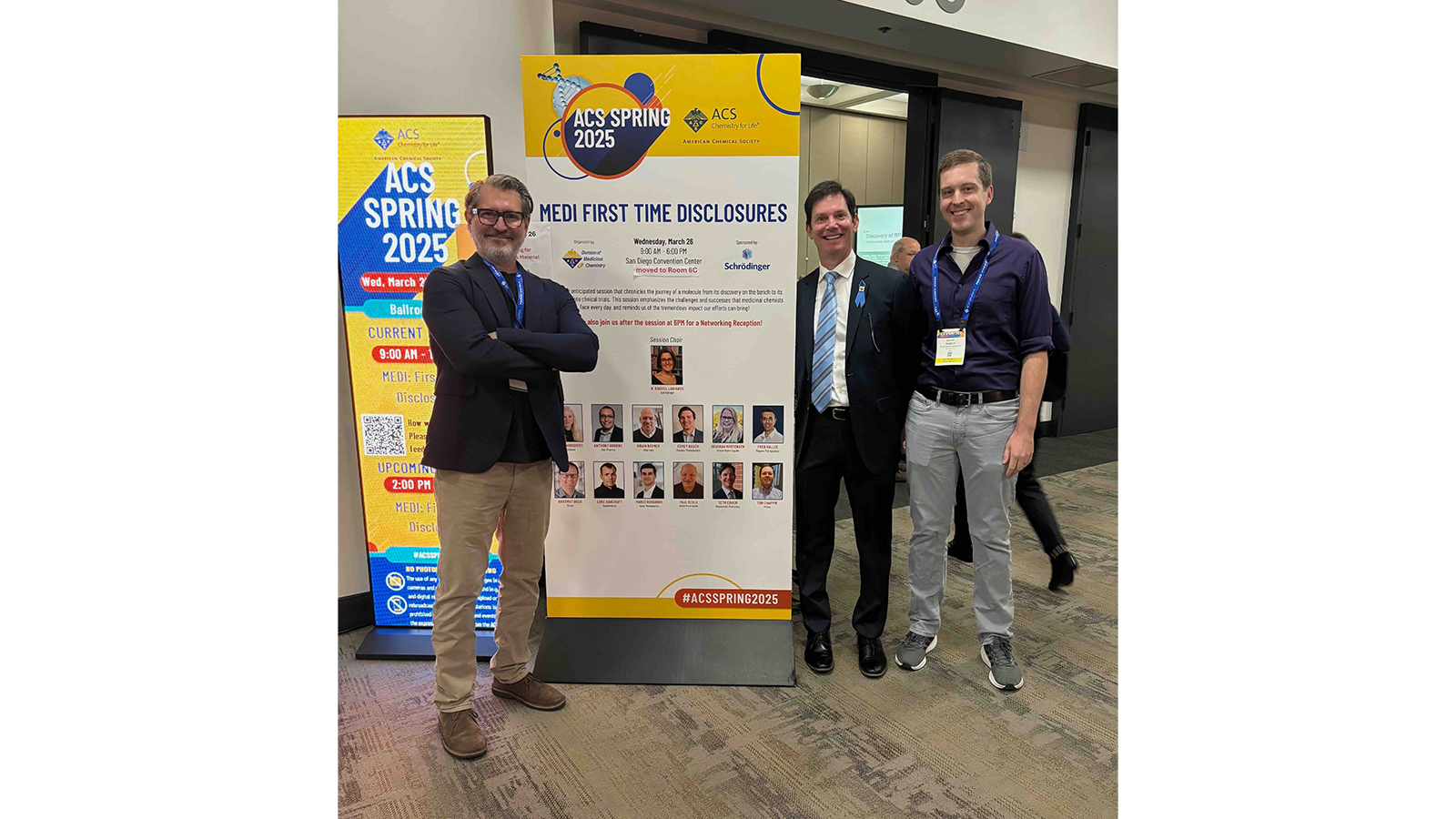 Professor Seth Cohen and others standing next to a sign at an event