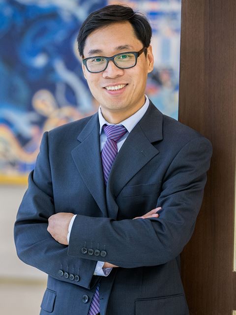 Ning Jiao smiling to camera in suit and tie