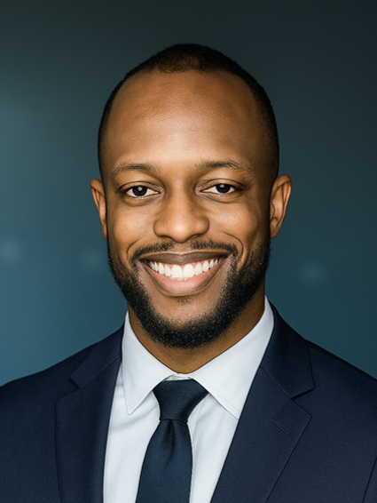 Ephraim Otumudia smiling, wearing a dark navy suit jacket set against a dark blue background. 