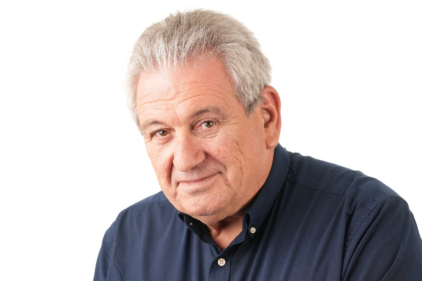 a man with grey hair wearing a blue shirt