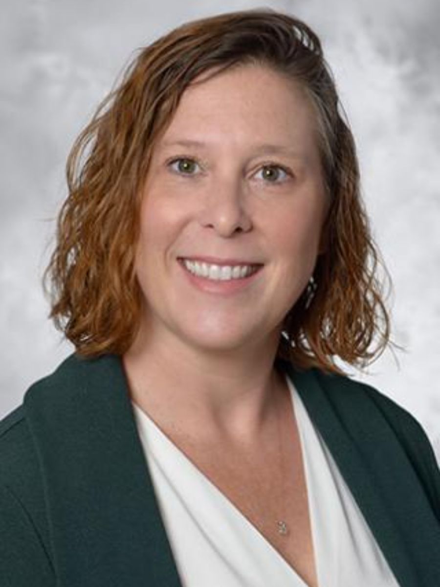 Erin Ratcliff smiling to camera in green jacket