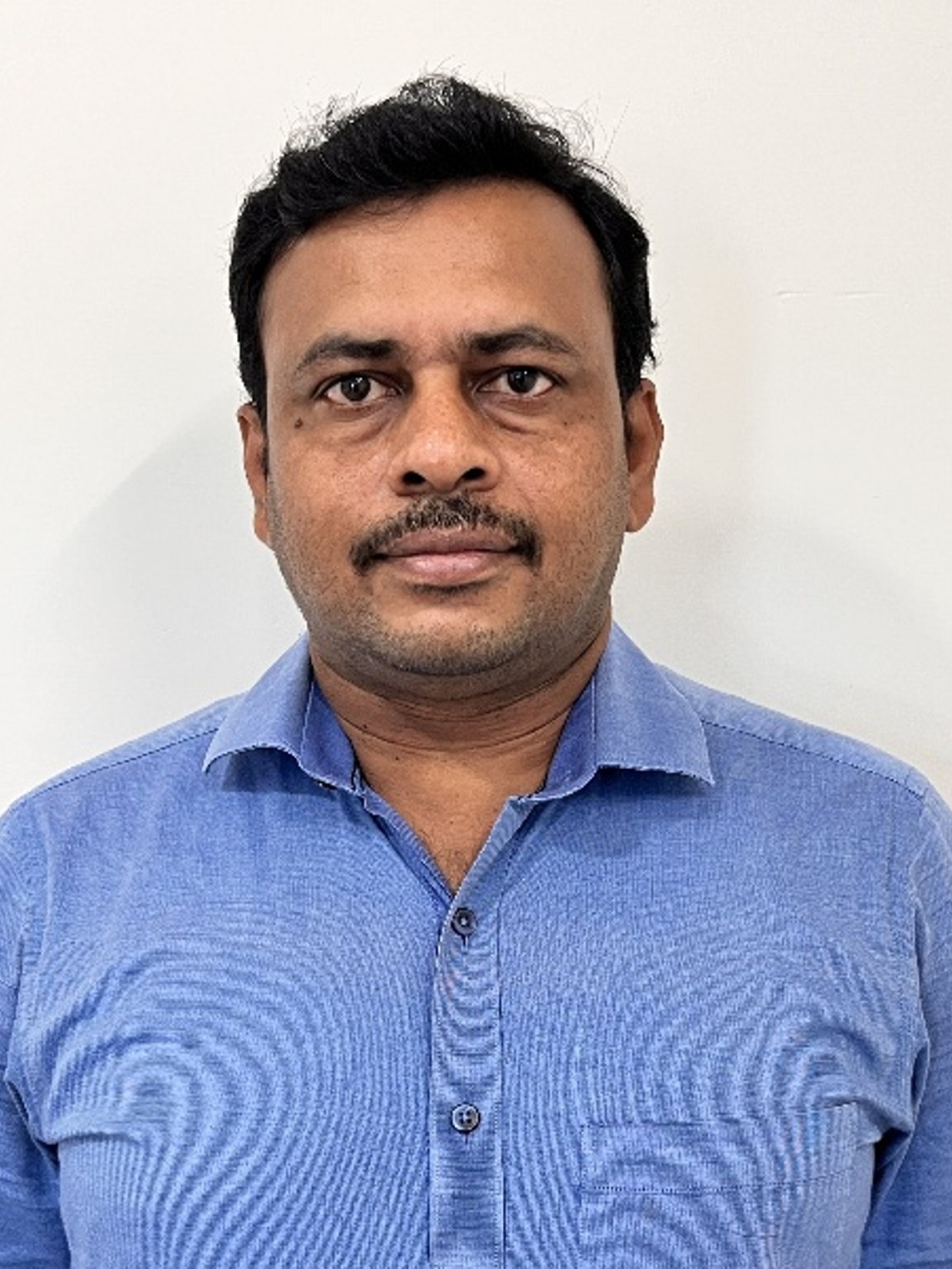 Vanchiappan Aravindan who has a mustache and is wearing a blue shirt