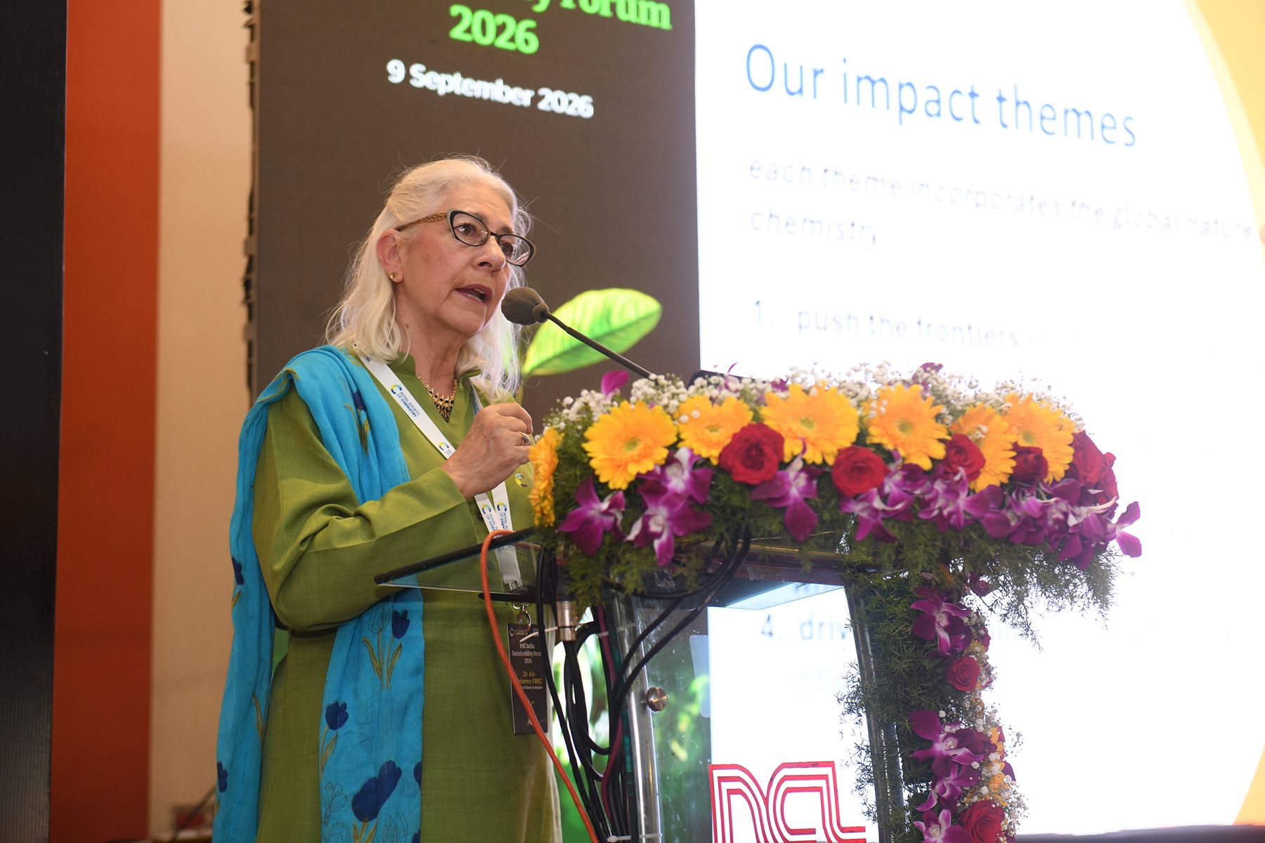 Dr Ale Palermo, RSC Head of Global Inclusion, talks at a lectern covered in flowers