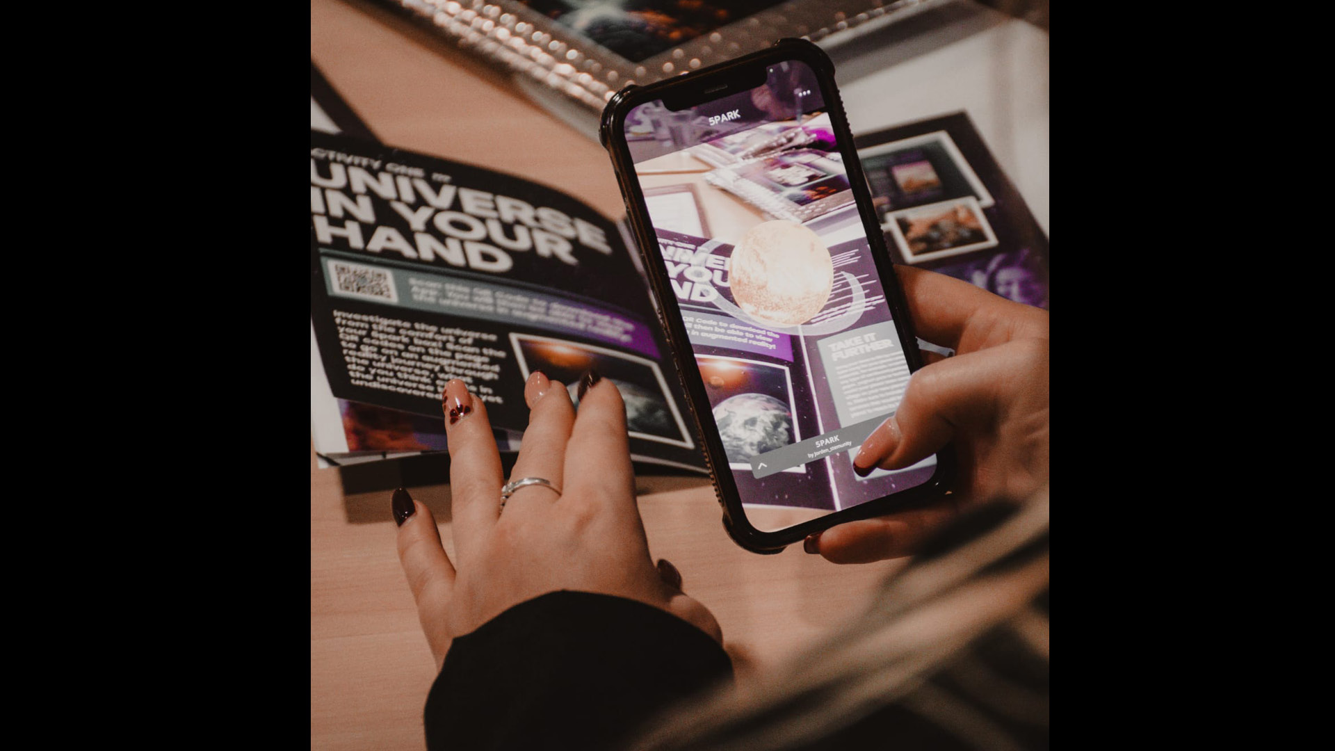 A pupil reading a STEMunity brochure of science information and taking a photo of a page of it with phone