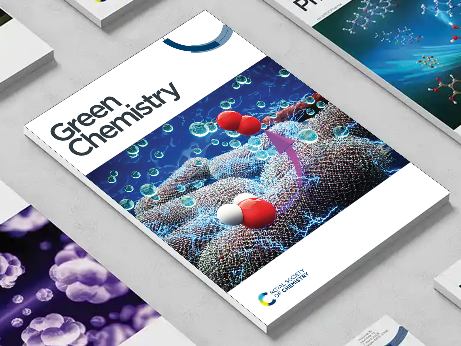 the Green Chemistry journal among a group of other journals on a desk