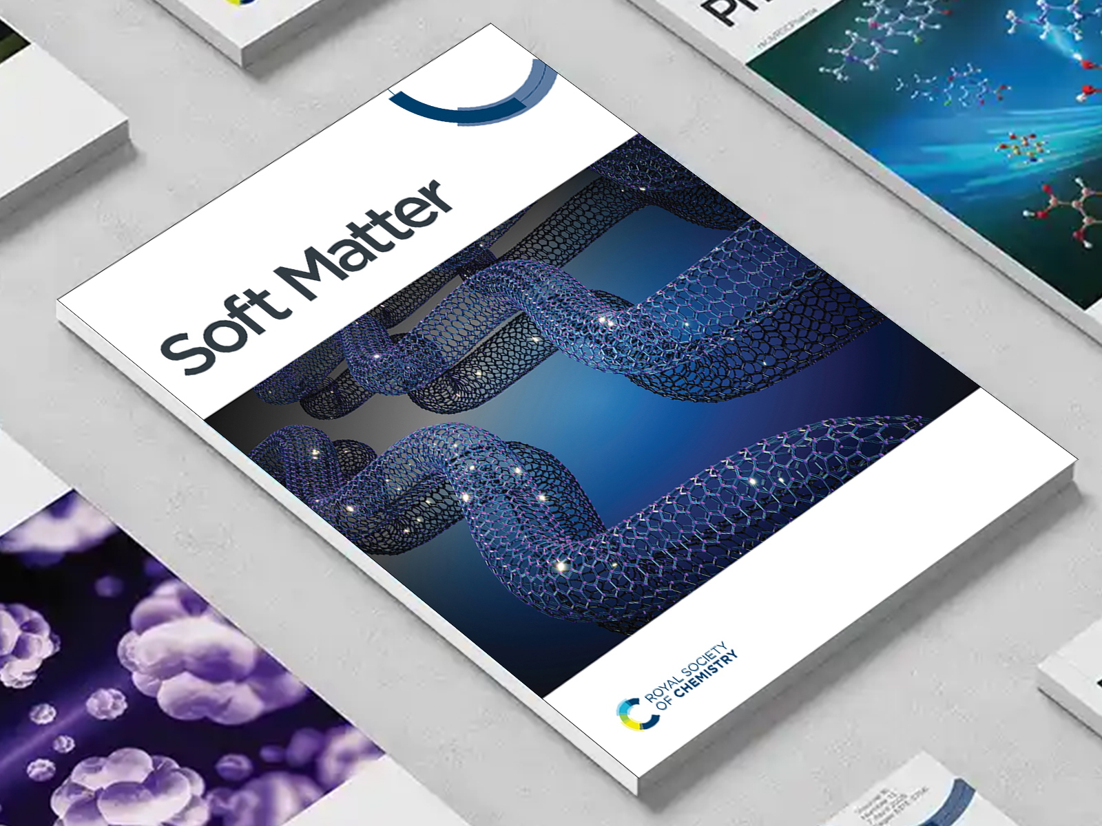 the Soft Matter journal among a group of other journals on a desk
