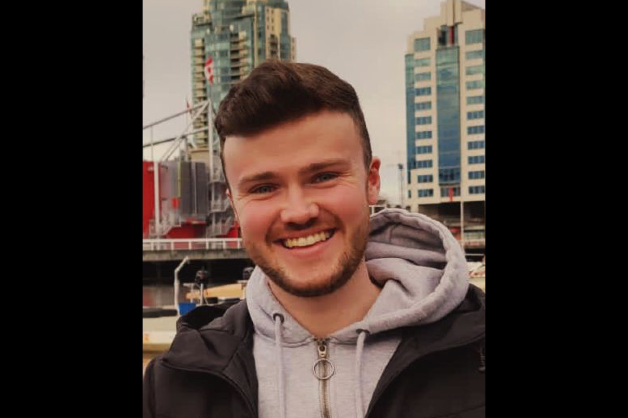 Conor Eivers smiling to camera in grey hoody