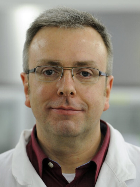 Oliver Einsle wearing glasses and a white coat